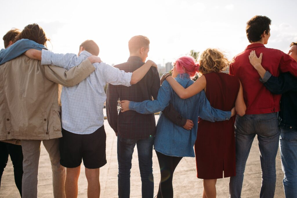 A Group Of Teenagers Who Were Former Rehab Patients Side Hugging One Another