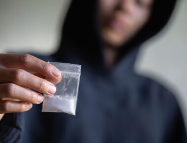 hand of addict man holding cocaine